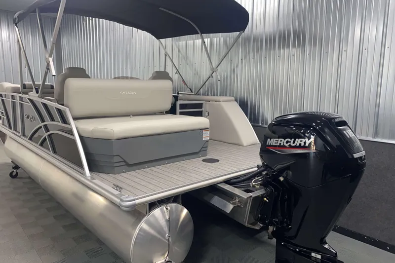 Slide: The Image of 2025 Sylvan 8 pontoon boat with Mercury outboard motor in a showroom. - 19