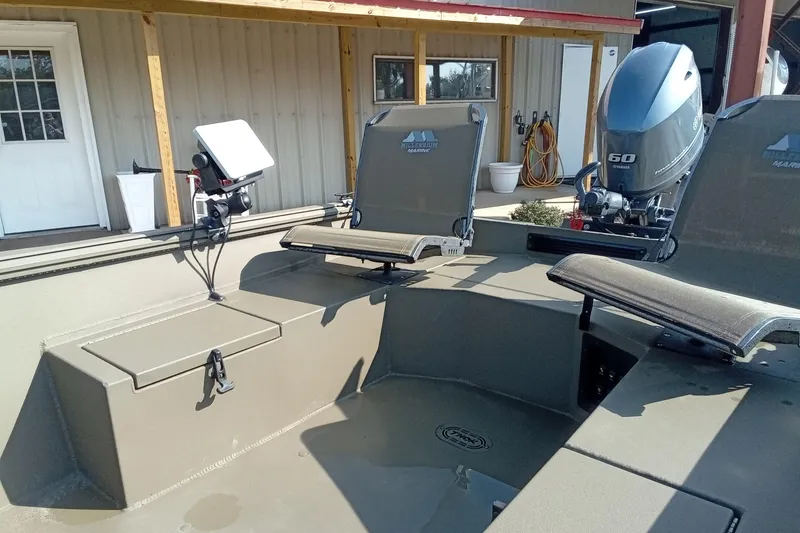 Slide: The Image of 2025 Thor 1754 Timber Hammer boat interior with seating and motor, docked near a building. - 11