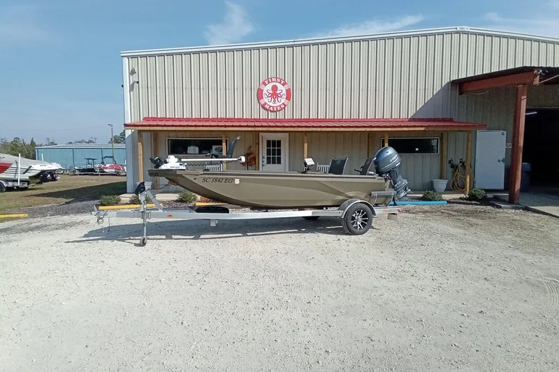 Slide: The Image of 2025 Thor 1754 Timber Hammer boat on trailer outside a warehouse. - 12