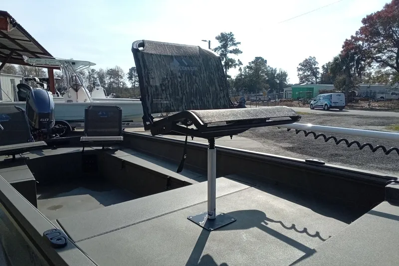 Slide: The Image of 2025 Thor 1754 Timber Hammer boat with elevated camo seat and motor in a sunny setting. - 4