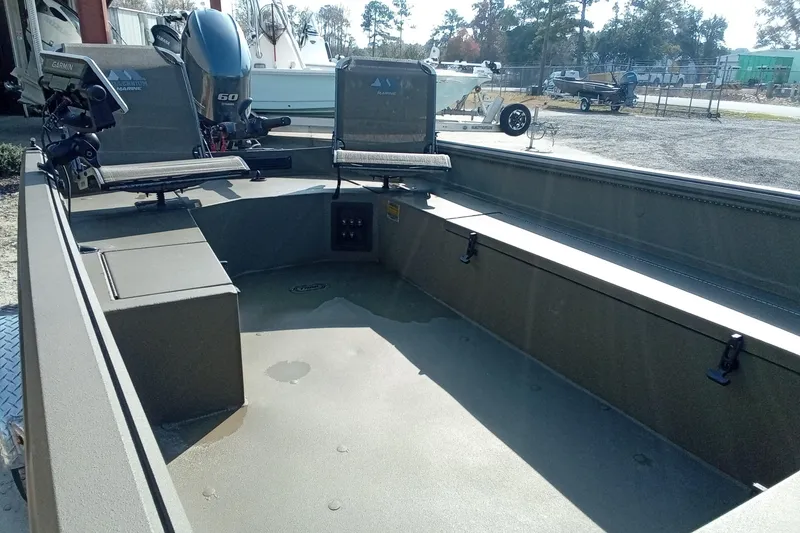 Slide: The Image of 2025 Thor 1754 Timber Hammer boat interior with seating and motor, parked outdoors. - 6