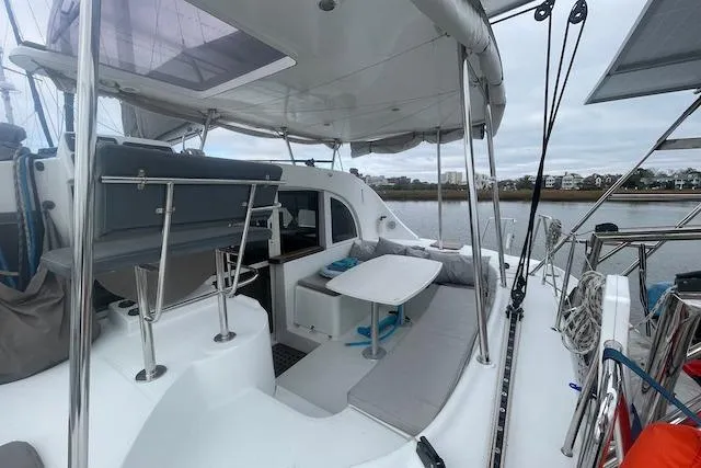 Slide: The Image of 2014 Lagoon 380 S2 yacht with outdoor seating, docked by calm waters. - 3