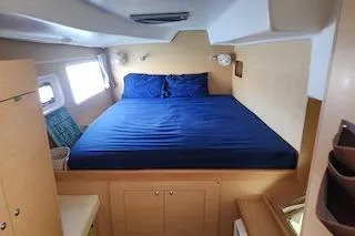 Slide: The Image of 2014 Lagoon 380 S2 yacht cabin with blue bedding and wooden interior. - 42