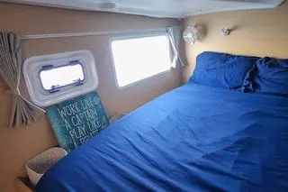 Slide: The Image of Cozy cabin interior of 2014 Lagoon 380 S2 with blue bedding and nautical decor. - 43