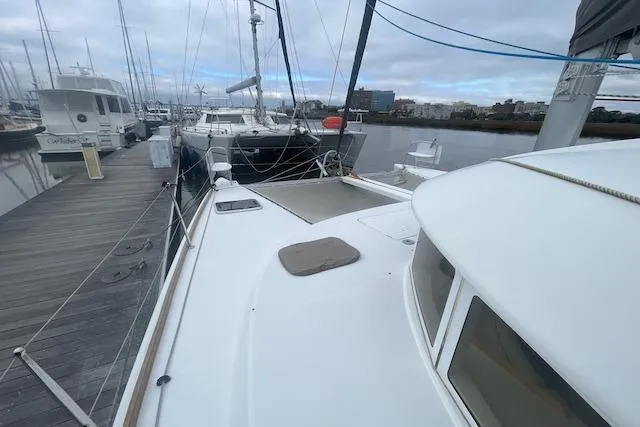 Slide: The Image of 2014 Lagoon 380 S2 catamaran cockpit with marina view, featuring helm and seating area. - 5