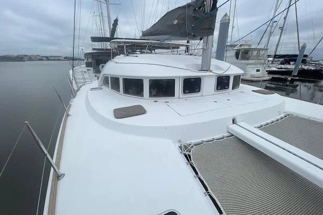 Slide: The Image of 2014 Lagoon 380 S2 catamaran with solar panel, docked in a marina under clear blue skies. - 9