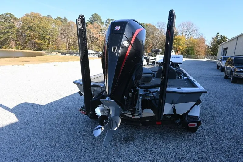 Slide: The Image of 2023 Vexus AVX2080 boat with powerful outboard motor, parked on gravel near trees. - 4