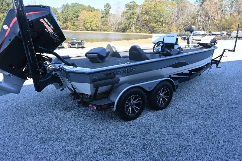 Slide: The Image of 2023 Vexus AVX2080 boat on trailer, parked near a lake with trees in background. - 5