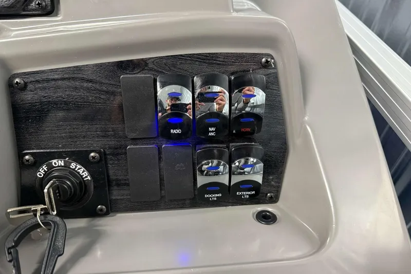 Slide: The Image of Control panel of 2026 Avalon Venture 2185 VRB with labeled switches and ignition key. - 23