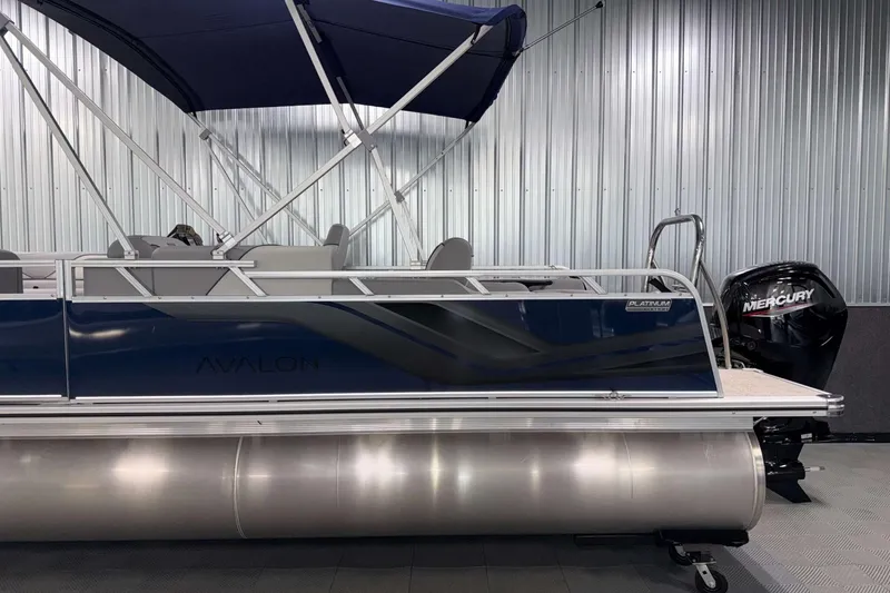 Slide: The Image of 2026 Avalon Venture 2185 VRB pontoon boat with Mercury engine, blue exterior, and canopy. - 7