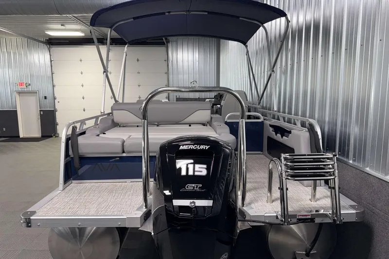 Slide: The Image of 2026 Avalon Venture 2185 VRB pontoon boat with Mercury 115 engine in a metal-walled showroom. - 9