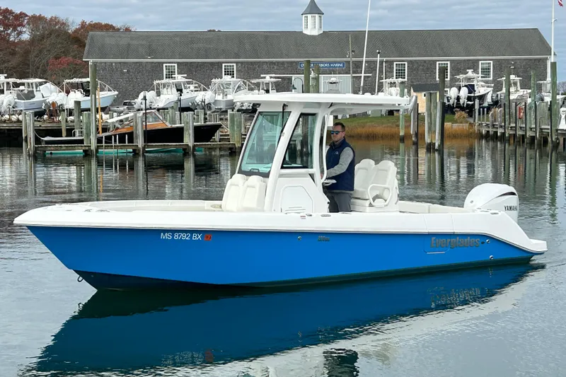 The Image of 2023 Everglades 235 Center Console boat docked at a marina with a person onboard. - 0