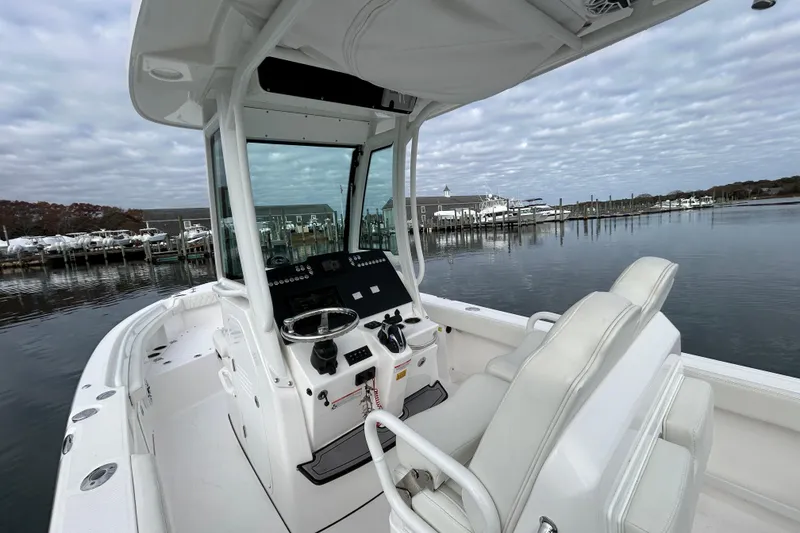 Slide: The Image of 2023 Everglades 235 Center Console boat docked at a marina under cloudy skies. - 10