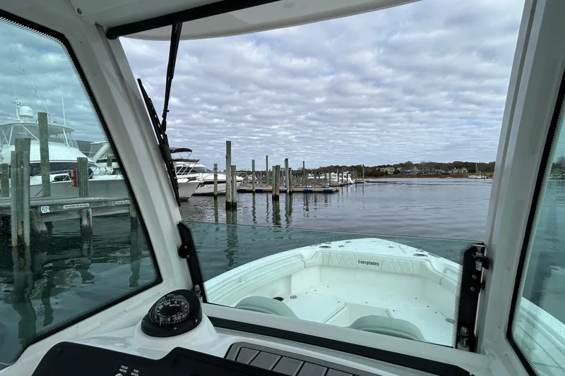 Slide: The Image of 2023 Everglades 235 Center Console boat docked at a marina under cloudy skies. - 15