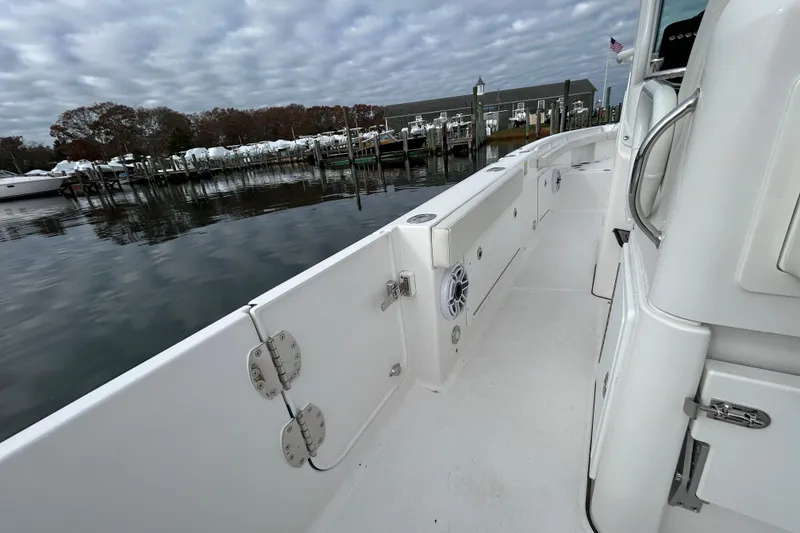 Slide: The Image of 2023 Everglades 235 Center Console boat docked at a marina under cloudy skies. - 20