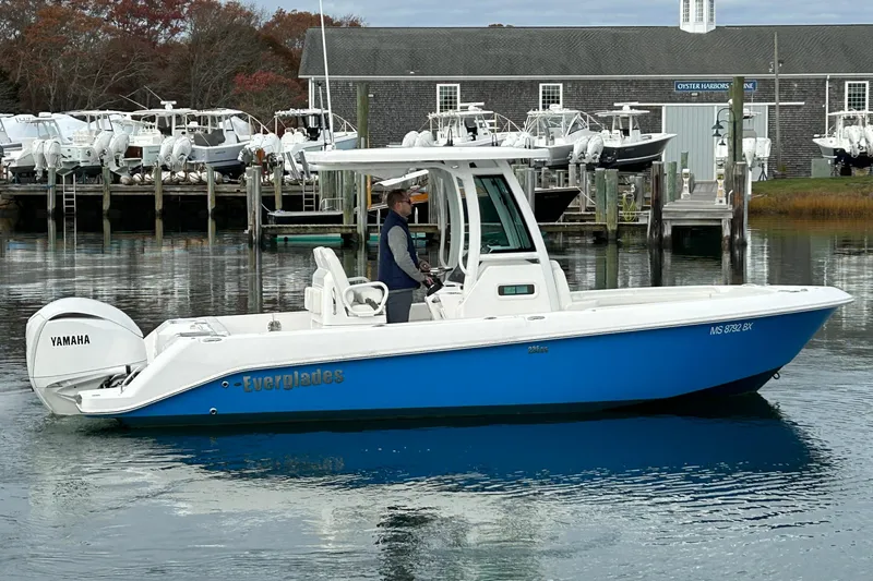 Slide: The Image of 2023 Everglades 235 Center Console boat on calm water near a marina. - 3