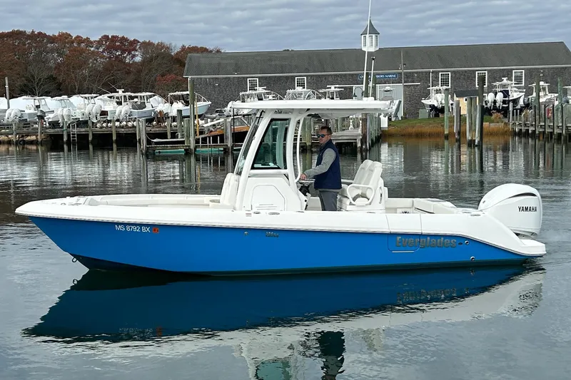 Slide: The Image of 2023 Everglades 235 Center Console boat on calm water near a marina. - 4