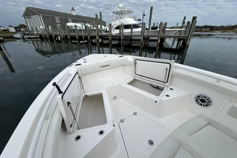 Slide: The Image of 2023 Everglades 235 Center Console boat docked, featuring open storage compartments. - 7