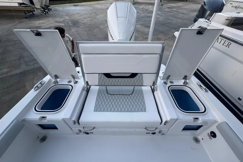 Slide: The Image of 2026 Blackfin 242 HB boat with white cushioned seating and storage compartments. - 12