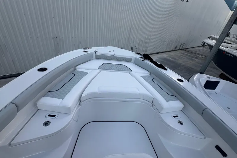 Slide: The Image of 2026 Blackfin 242 HB boat with white seating, docked near waterfront homes. - 18