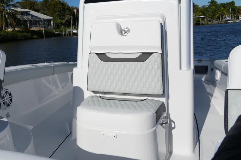 Slide: The Image of 2026 Blackfin 242 HB boat interior with quilted seating, docked by a scenic waterfront. - 23