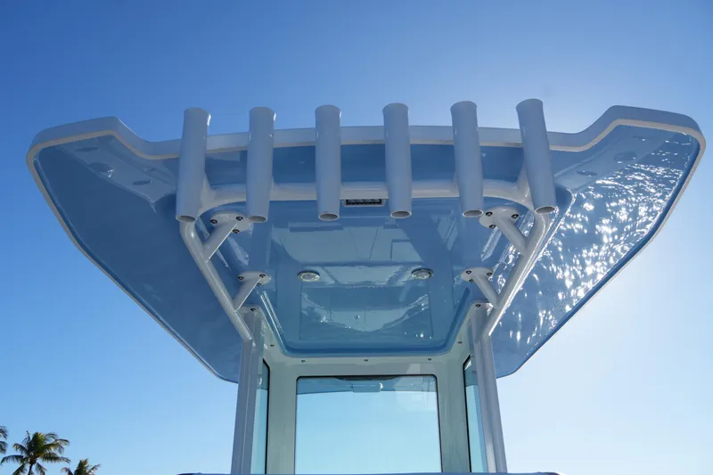 Slide: The Image of 2026 Blackfin 242 HB boat top view with rod holders against clear blue sky. - 24