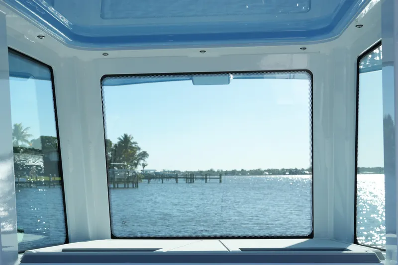 Slide: The Image of View from 2026 Blackfin 242 HB boat cabin overlooking serene waterfront and docks. - 42