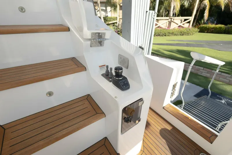 Slide: The Image of Staircase and controls on 2021 Azimut Fly 72 yacht, featuring teak steps and outdoor view. - 11