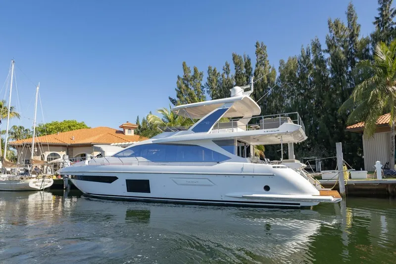 Slide: The Image of 2021 Azimut Fly 72 yacht docked by waterfront homes and lush trees. - 3