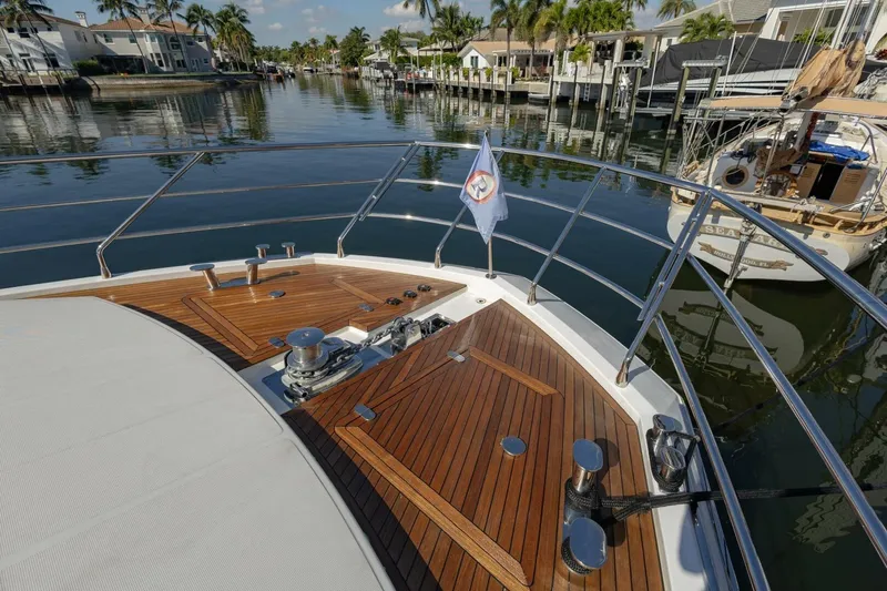 Slide: The Image of Bow of 2021 Azimut Fly 72 yacht with polished wood deck and scenic waterfront view. - 65