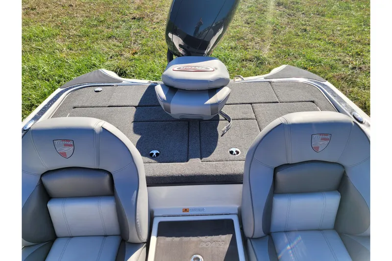 Slide: The Image of 2024 Triton 18 TrX boat interior with gray seating and deck, outdoors. - 10