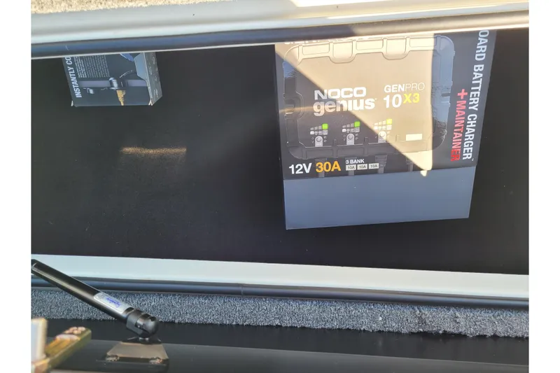 Slide: The Image of 12V NOCO Genius battery charger in 2024 Triton 18 TrX boat compartment. - 12