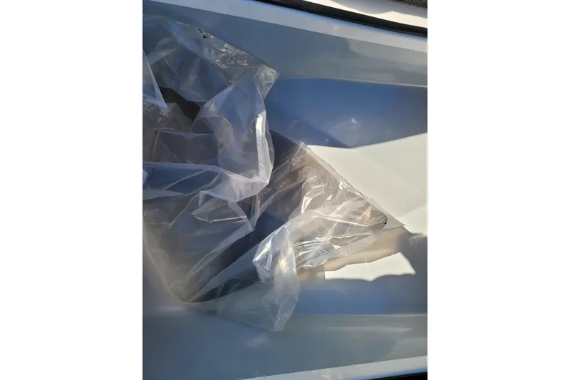 Slide: The Image of Plastic-wrapped interior of 2024 Triton 18 TrX boat compartment. - 13