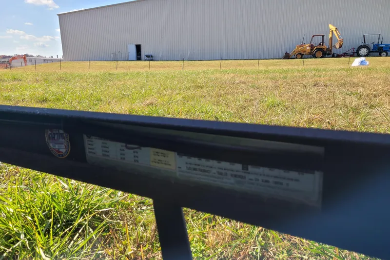 Slide: The Image of Outdoor scene with a large building, tractors, and grassy field under a blue sky. - 18