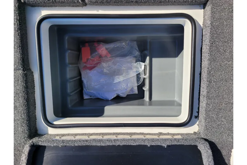 Slide: The Image of 2024 Triton 18 TrX storage compartment with plastic bag and red item inside. - 6