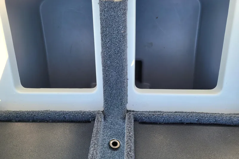 Slide: The Image of 2024 Triton 18 TrX boat interior storage compartments with carpeted finish. - 8