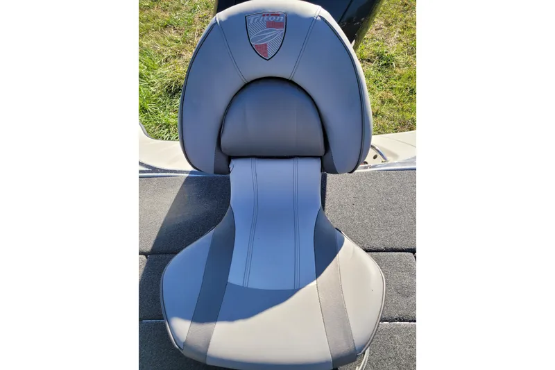Slide: The Image of 2024 Triton 18 TrX boat seat with logo, gray upholstery, outdoor setting. - 9