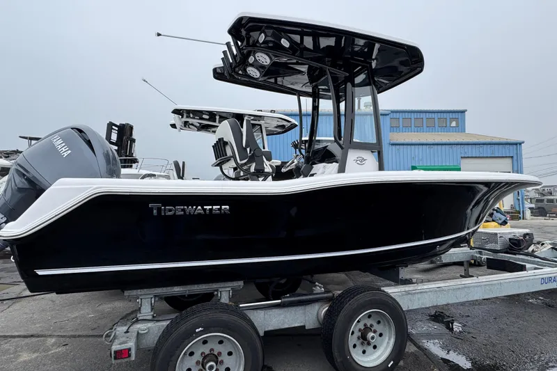 The Image of 2026 Tidewater 210 CC Adventure boat on trailer, featuring sleek black design and Yamaha engine. - 1