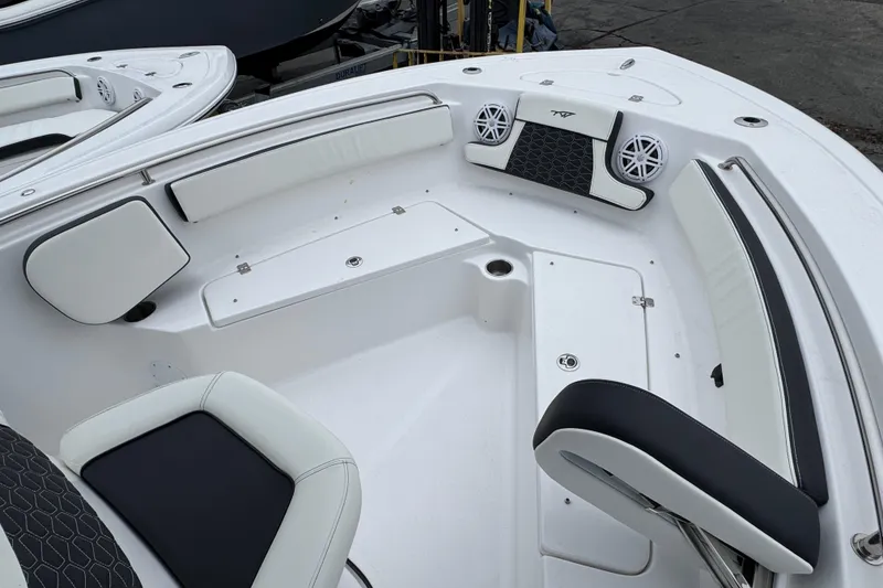 Slide: The Image of 2026 Tidewater 210 CC Adventure boat interior with white seating and speakers. - 18