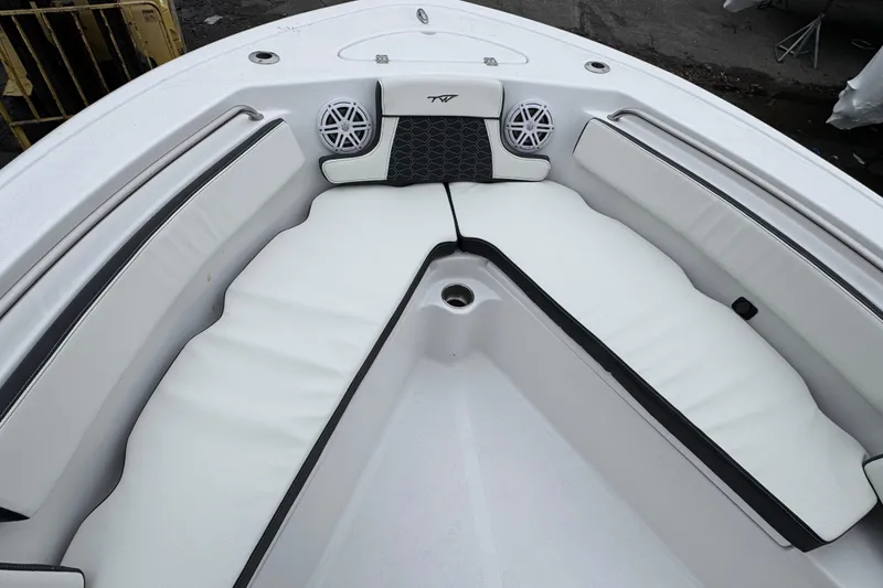 Slide: The Image of 2026 Tidewater 210 CC Adventure boat interior with white cushioned seating and speakers. - 21
