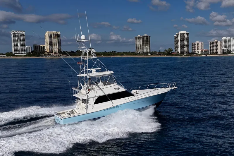 The Image of 1998 Viking 50 Convertible yacht cruising near coastal city skyline. - 0