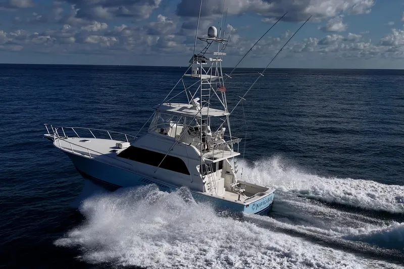 Slide: The Image of 1998 Viking 50 Convertible yacht cruising on open ocean under cloudy sky. - 10