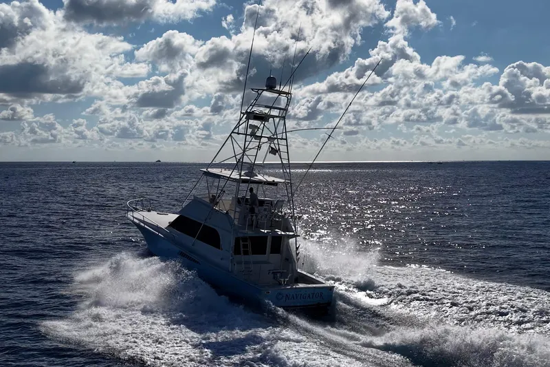 Slide: The Image of 1998 Viking 50 Convertible yacht navigating ocean waves under a cloudy sky. - 11