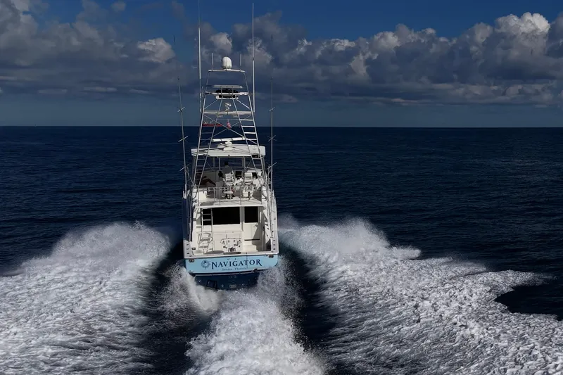 Slide: The Image of 1998 Viking 50 Convertible yacht cruising on open ocean under cloudy sky. - 13