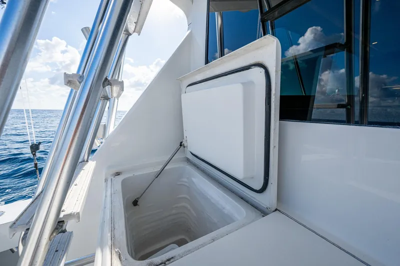 Slide: The Image of Open storage compartment on 1998 Viking 50 Convertible yacht, ocean view in background. - 27