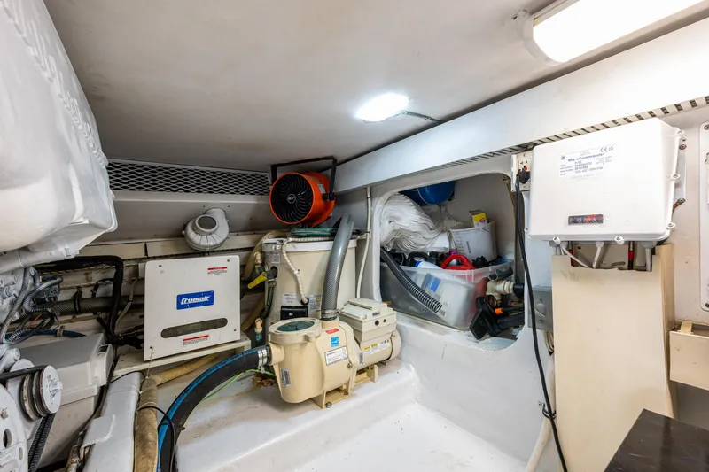 Slide: The Image of Engine room of 1998 Viking 50 Convertible yacht, featuring various mechanical components and storage. - 47