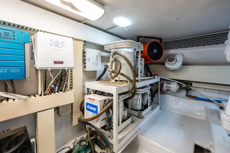 Slide: The Image of Engine room of a 1998 Viking 50 Convertible yacht, featuring mechanical equipment and wiring. - 48
