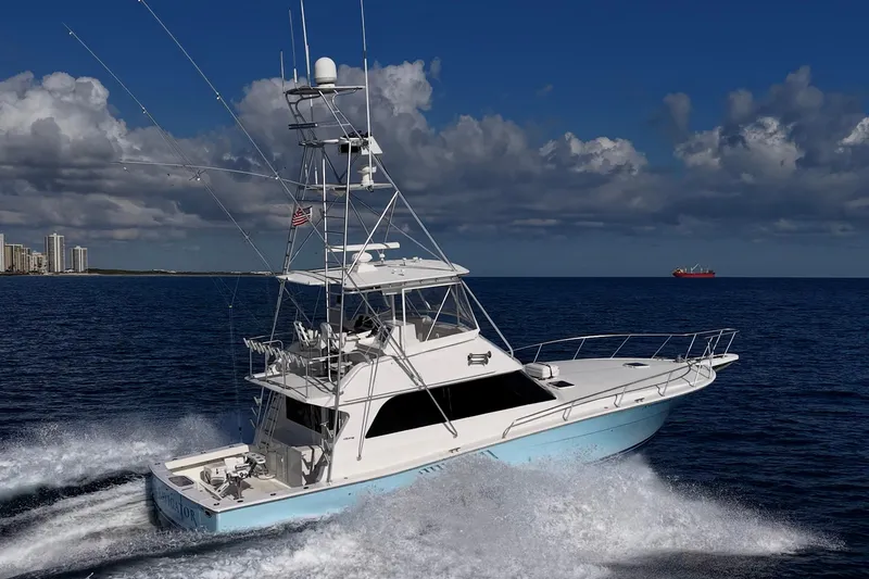 Slide: The Image of 1998 Viking 50 Convertible yacht cruising on open sea under clear skies. - 5