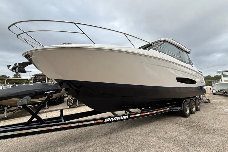 Slide: The Image of 2026 Regal 36 Grande Coupe boat on trailer, displayed outdoors under cloudy sky. - 3