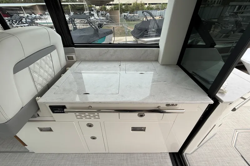 Slide: The Image of Interior of 2026 Regal 36 Grande Coupe yacht with sleek countertop and seating. - 36